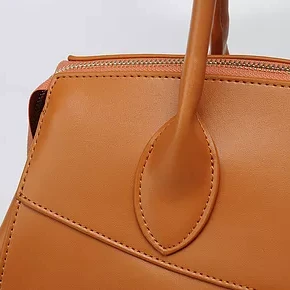 A close up of the handle on a brown bag