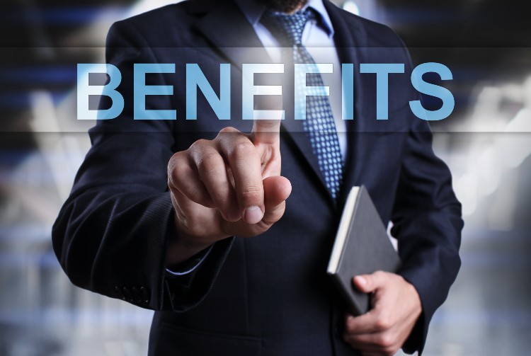 A man in suit and tie pointing to the word benefits.