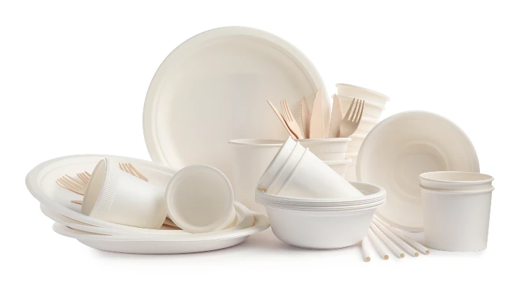 A group of white plates and bowls with utensils.